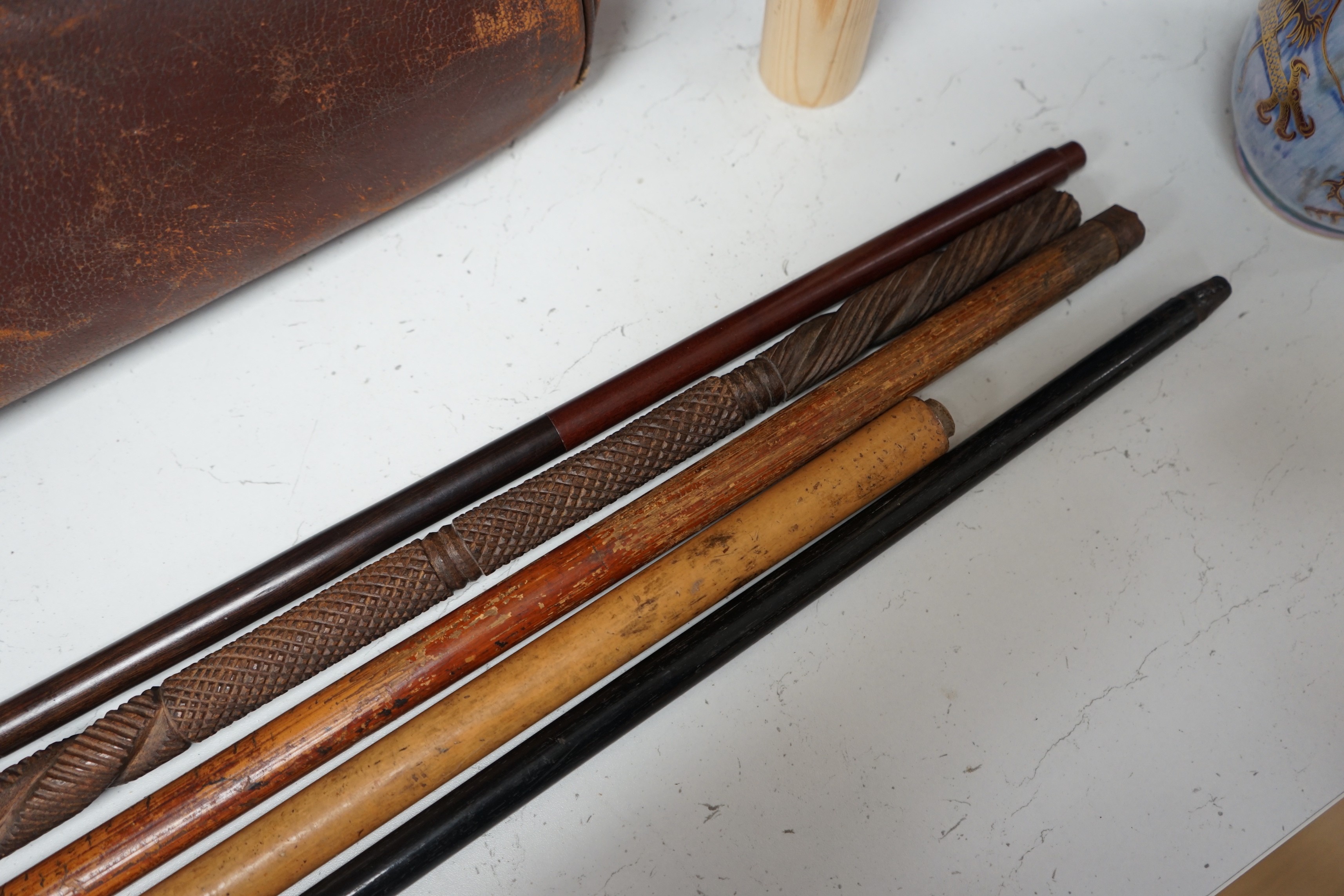 A collection of five walking sticks including one silver mounted and a Gladstone bag